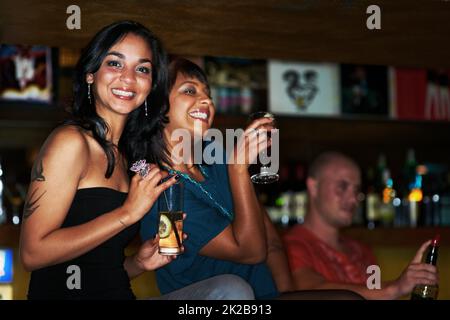 Out on the town. Two beautiful young girls out partying together and enjoying cocktails. Stock Photo