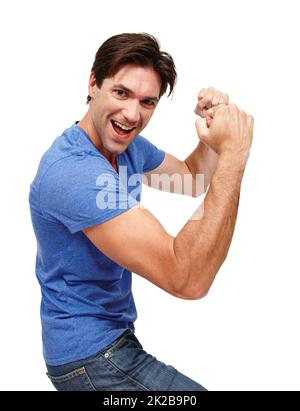Victory is mine. Studio portrait of a handsome young man punching the air in excitement. Stock Photo