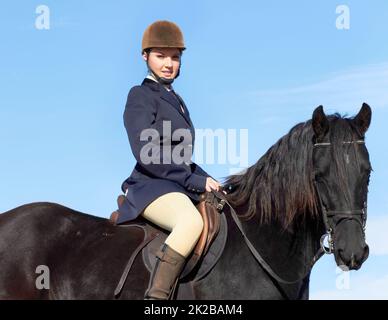 He rides like the wind. Shot of a beautiful young woman riding her horse. Stock Photo