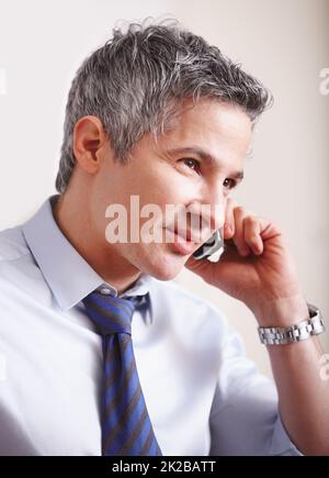 Networking with clients. A handsome mature businessman taking a call on his smartphone. Stock Photo