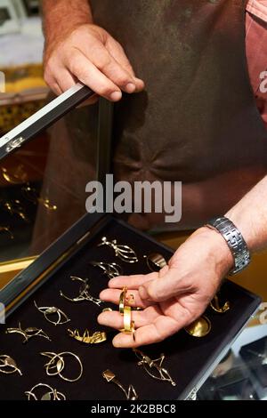 Beautiful and carefully crafted. Cropped view of a jeweler showing his handiwork. Stock Photo