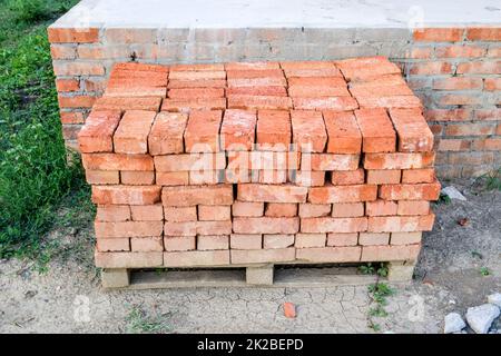 The red brick folded neatly on the foundation of the house. Home construction Stock Photo