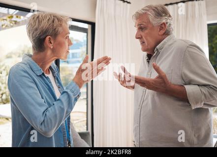 Mature couple fight, divorce and conflict problem in conversation with anger, blame and stress at home. Angry woman, frustrated man and senior Stock Photo