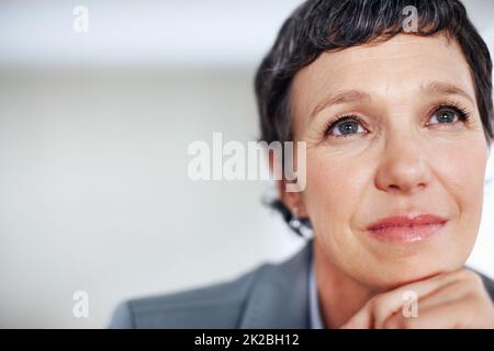 Pensive female executive. Closeup of contemplative female executive lost in thought. Stock Photo