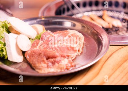 Korean traditional style fresh pork beef belly BBQ on stove serve wood table Stock Photo