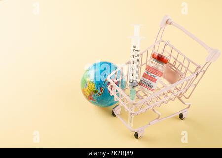 Shopping cart with vaccine vials bottles and syringes for vaccination against coronavirus Stock Photo