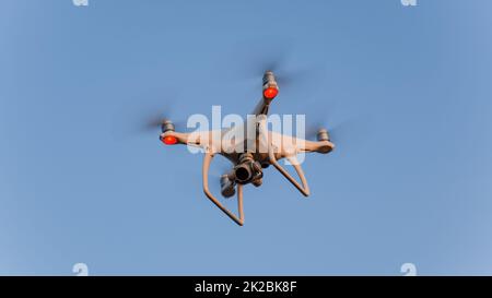 The drone, hovering in the sky. Flight quadrocopters Stock Photo
