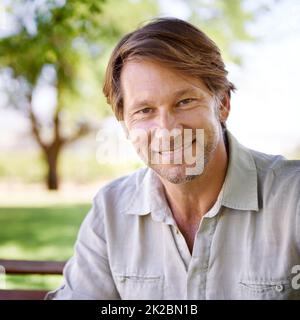 I feel most at home in the comfort of nature. Portrait of a handsome mature man enjoying a day in the park. Stock Photo