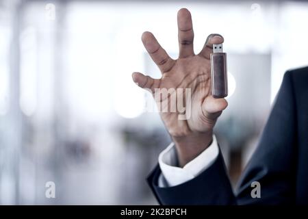These things are so efficient. Cropped shot of an african businessman holding up a usb. Stock Photo