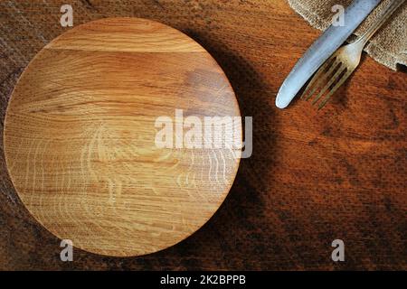 Vintage silverware, plate, napkin on rustic wooden background. Top view of kitchen setting table Stock Photo