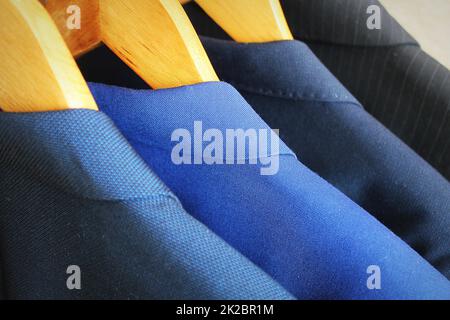 Row of men's suits hanging in closet Stock Photo