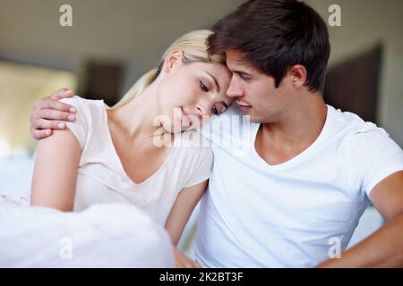 The best kind of comfort zone. Shot of a sad young woman being comforted by her husband in bed. Stock Photo