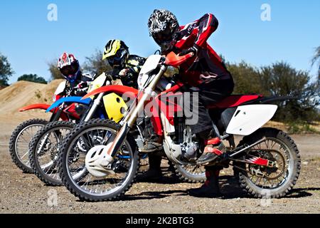 Showing off their wheels. Three bikers sitting on their motorcycles ready for a race. Stock Photo