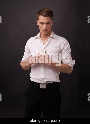 Broody attractiveness. Portrait of a handsome young man against a black background. Stock Photo