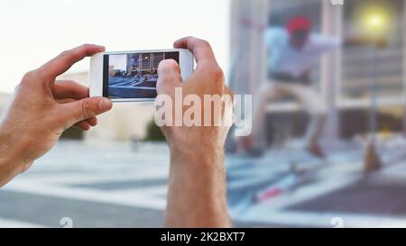 Capturing real life moments. Cropped shot of a man taking a picture of his friend doing tricks on his skateboard. Stock Photo