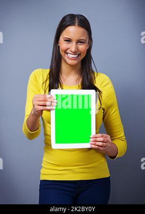 Check out your new website. Studio portrait of an attractive young woman holding a tablet against a blue background. Stock Photo