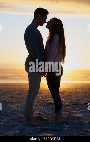 Youre nothing short of my everything. Silhouette shot of a young couple on the beach. Stock Photo