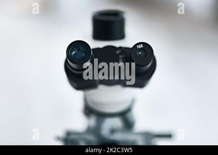 Place your eyes as close as you can. Still life shot of the eyepiece on a microscope in a laboratory. Stock Photo