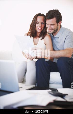 We should be able to afford that new car now. A young married couple discussing their home finances together. Stock Photo