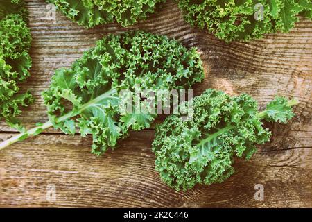 Fresh leaf of kale cabbage on wooden background. Green vegetable leaves. Top view . Healthy eating, vegetarian food Stock Photo