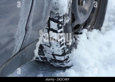 Closeup of car tires in winter on the road covered with snow Stock Photo