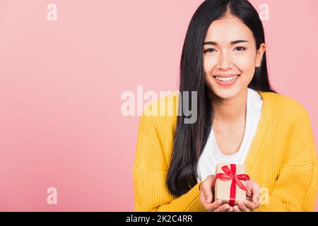 woman smiling holding small gift box on hands Stock Photo