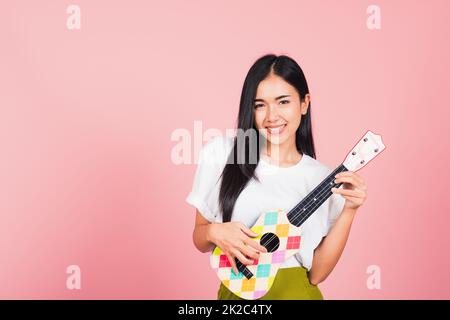 woman teen confident smiling face hold acoustic Ukulele guitar Stock Photo