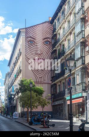 Large mural of woman's face high on external party wall of building, Calle de la Magdalena, Madrid, Spain. Stock Photo
