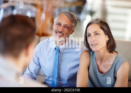 Theyre a great team - in life AND business. A cropped shot of a mid adult couple having a meeting with a young businessman. Stock Photo