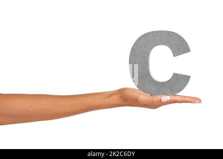 C what I did there.... A young woman holding a capital letter C isolated on a white background. Stock Photo