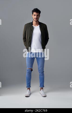 Confidence sure looks good on him. Studio shot of a handsome young man posing against a grey background. Stock Photo