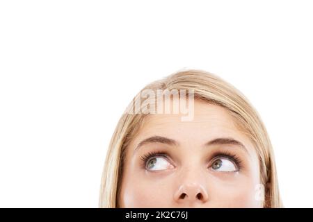 Intriguing..... Cropped studio shot of a young blonde woman looking up at copyspace isolated on white. Stock Photo