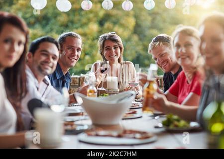 Nothing by good vibes at our table. Portrait of a group of happy young friends sharing a meal at a backyard dinner party. Stock Photo