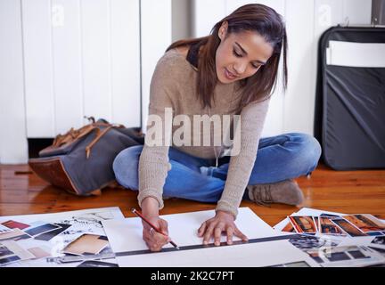 Working to develop her portfolio. A young woman working on her portfolio at home. Stock Photo