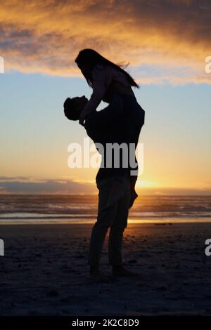 You have my heart. Silhouette shot of a young couple on the beach. Stock Photo