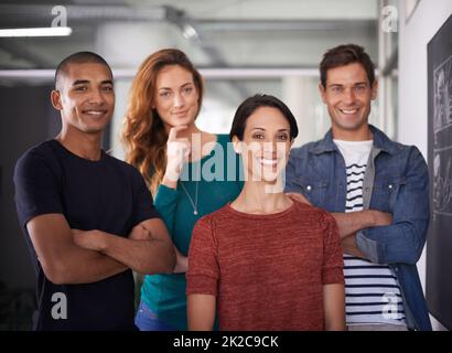 Positive about work. Cropped portrait of a team of young creative professionals standing in the office. Stock Photo