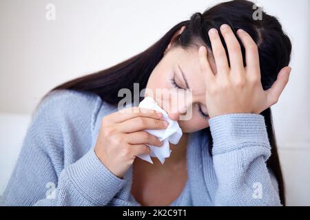 Depression can effect anyone. Cropped shot of a young woman holding a tissue and looking sad. Stock Photo