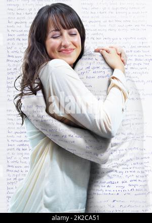 Embracing the english language. A young woman embracing another person who is actually part of the words on the wall. Stock Photo