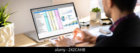 Man Working With Electronic Spreadsheet Reports Stock Photo