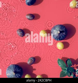 Panoramic water banner background. Fresh ripe fig fruits and slices swimming in water. Natural direct sunlight with shadows. Ripples, water rings on Stock Photo