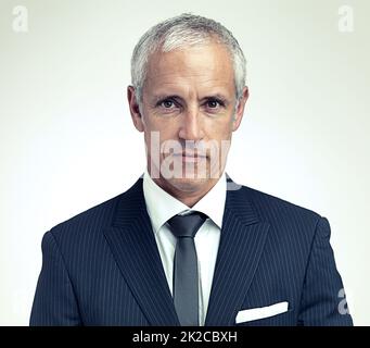 The man in charge. A cropped portrait of a serious mature man wearing a pinstripe suit. Stock Photo