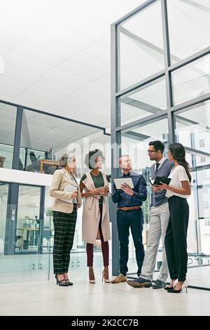 Business is built on a solid foundation of relationships. Shot of a group of colleagues having an informal meeting in an office. Stock Photo