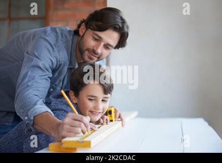 Let me show you what to do.... A father and son doing woodwork together. Stock Photo