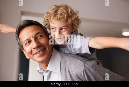 Grandpas are the best. A grandfather giving his grandson a piggyback ride. Stock Photo