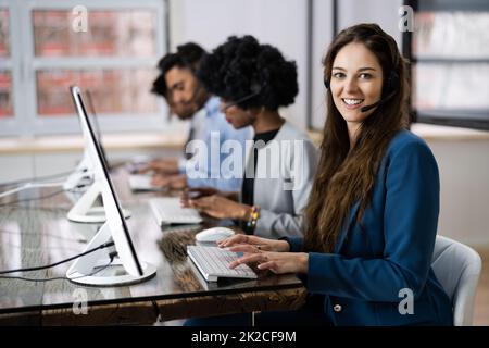 Positive Customer Services Agent With Headset Working Stock Photo