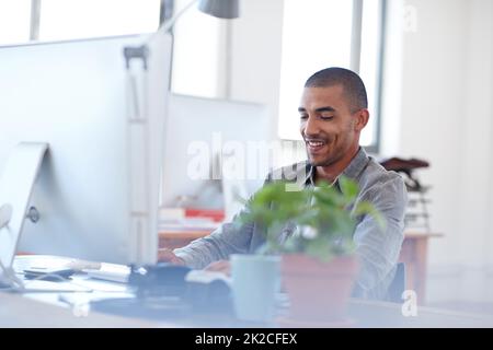 Feeling good about my profession. Young multi-ethnic man at work in a bright office space. Stock Photo