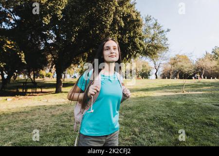 Looking to the future. Young college student girl wearing aquamarina t shirt looking at the horizon in the campus. Stock Photo