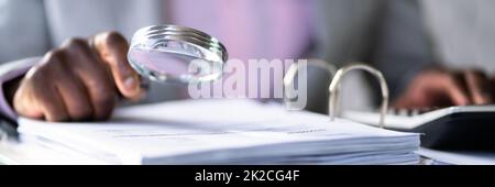 Auditor Using Magnifying Glass For Audit Stock Photo