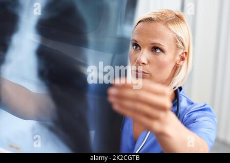 Taking a closer look at the problem. A beautiful young doctor examining