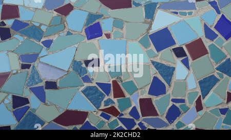 Colorful abstract ceramic mosaic. Close up. Mosaic on the wall with fragments of blue, white, black colors with pieces. Stock Photo